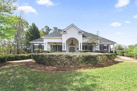 a white house with a gray roof and a green lawn